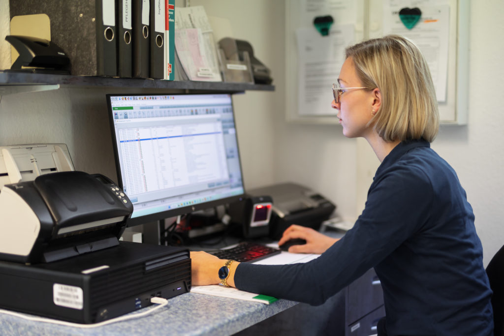Eine Frau mit blonden Haaren arbeitet an einem Computer in einer Apotheke. In der Trommsdorff Apotheke in Erfurt